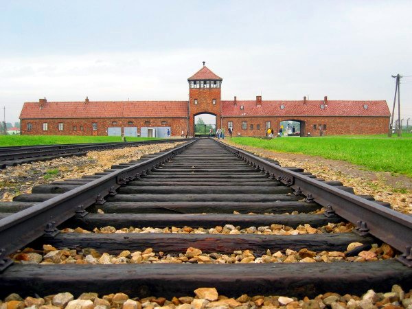 Vhodni objekt uničevalnega taborišča Auschwitz II, skozi katerega so pripeljali vlaki z interniranci. (Foto: Wikipedia)